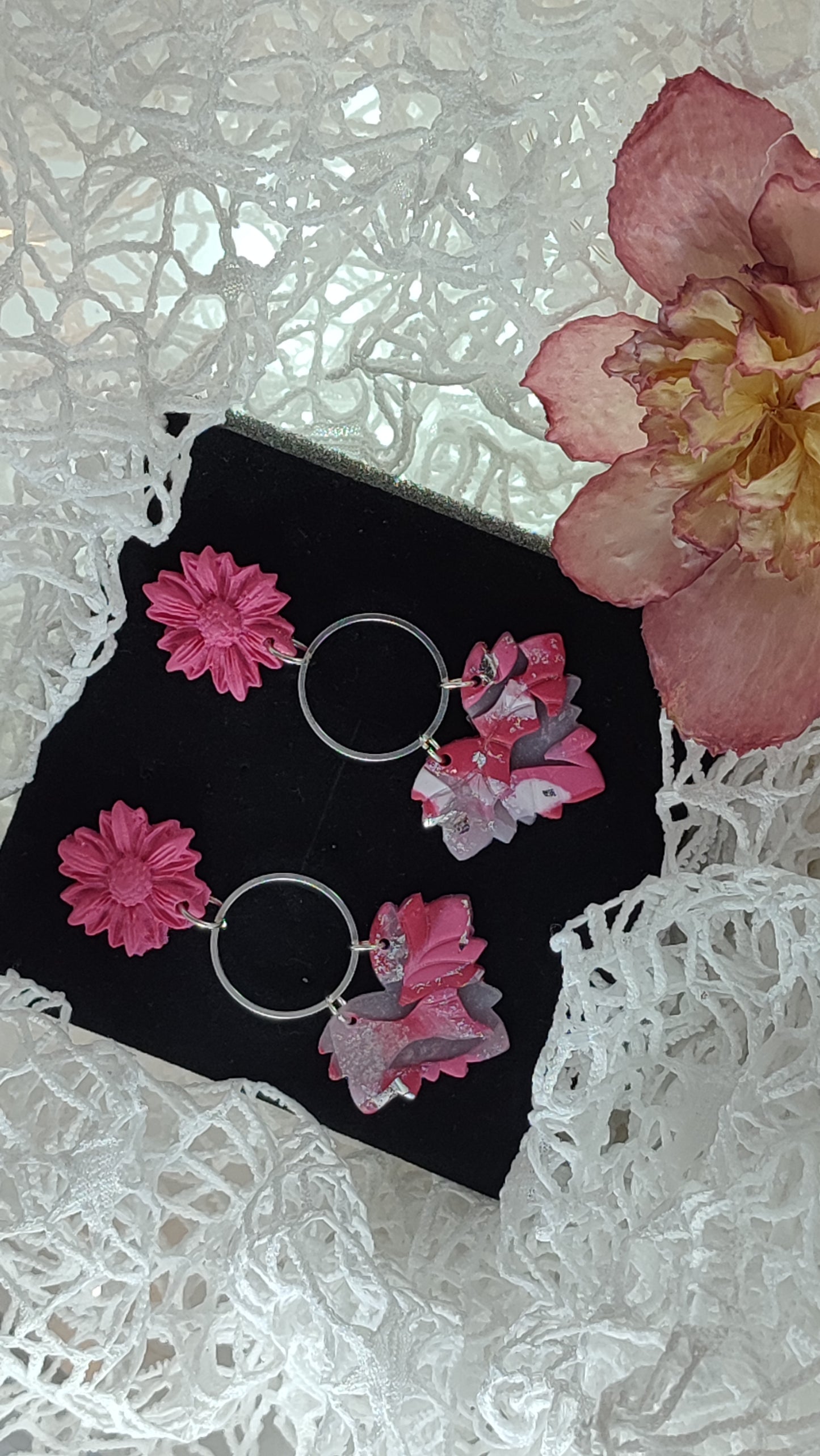Handcrafted polymer clay earrings featuring a beautiful combination of pink, silver, and white colors. The unique design showcases a playful mix of shapes and textures, perfect for adding a touch of elegance to any outfit.