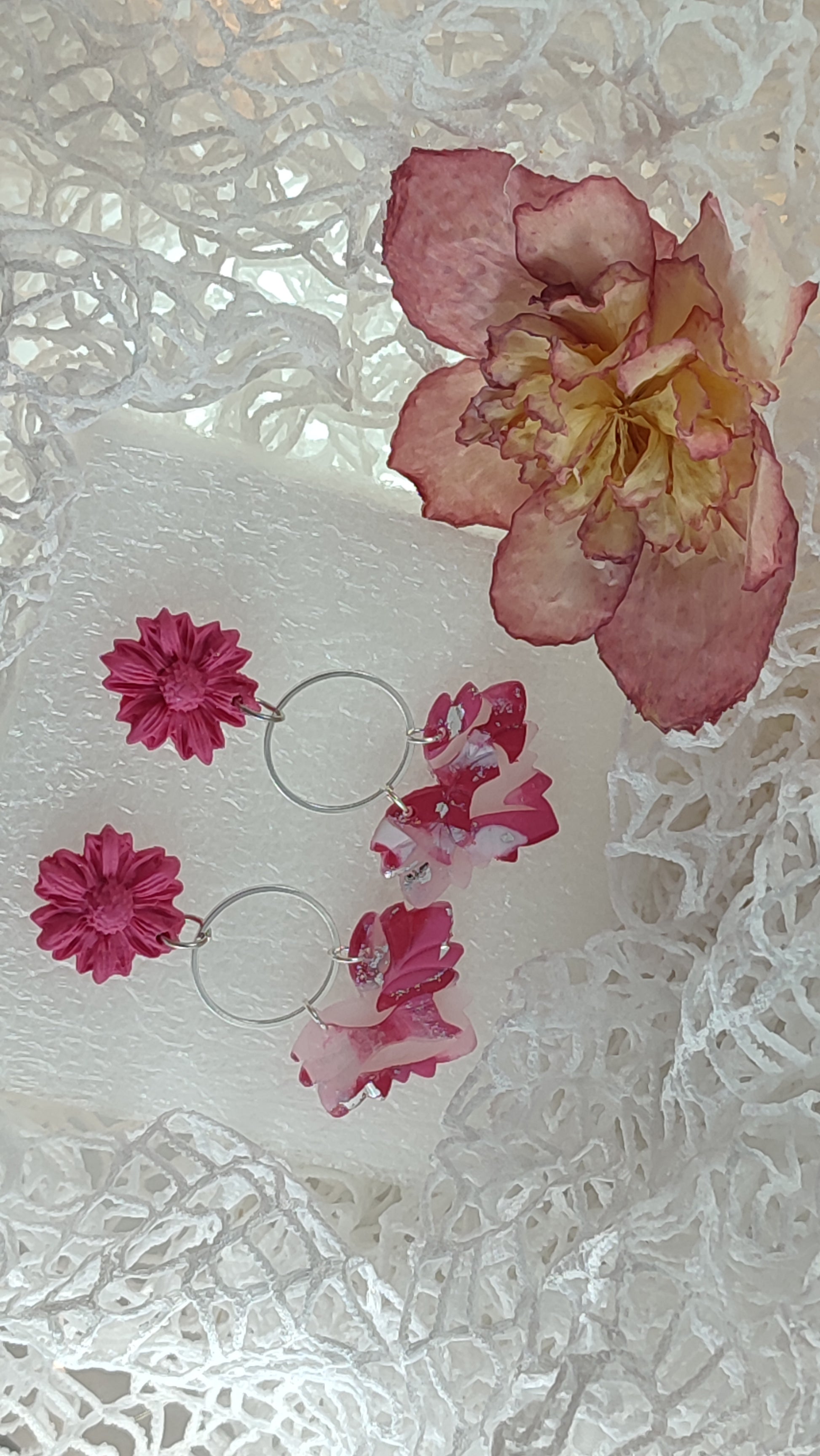 Handcrafted polymer clay earrings featuring a beautiful combination of pink, silver, and white colors. The unique design showcases a playful mix of shapes and textures, perfect for adding a touch of elegance to any outfit.