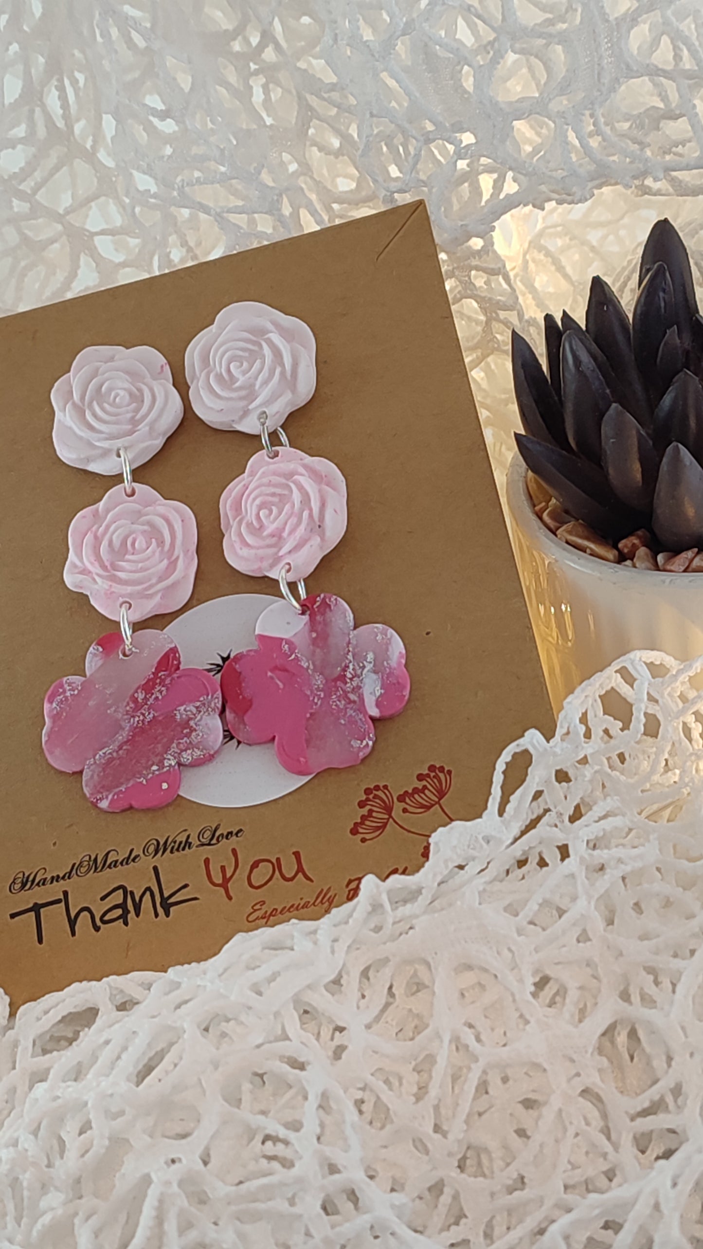 Handcrafted polymer clay earrings featuring a beautiful combination of pink, silver, and white colors. The unique design showcases a playful mix of shapes and textures, perfect for adding a touch of elegance to any outfit.