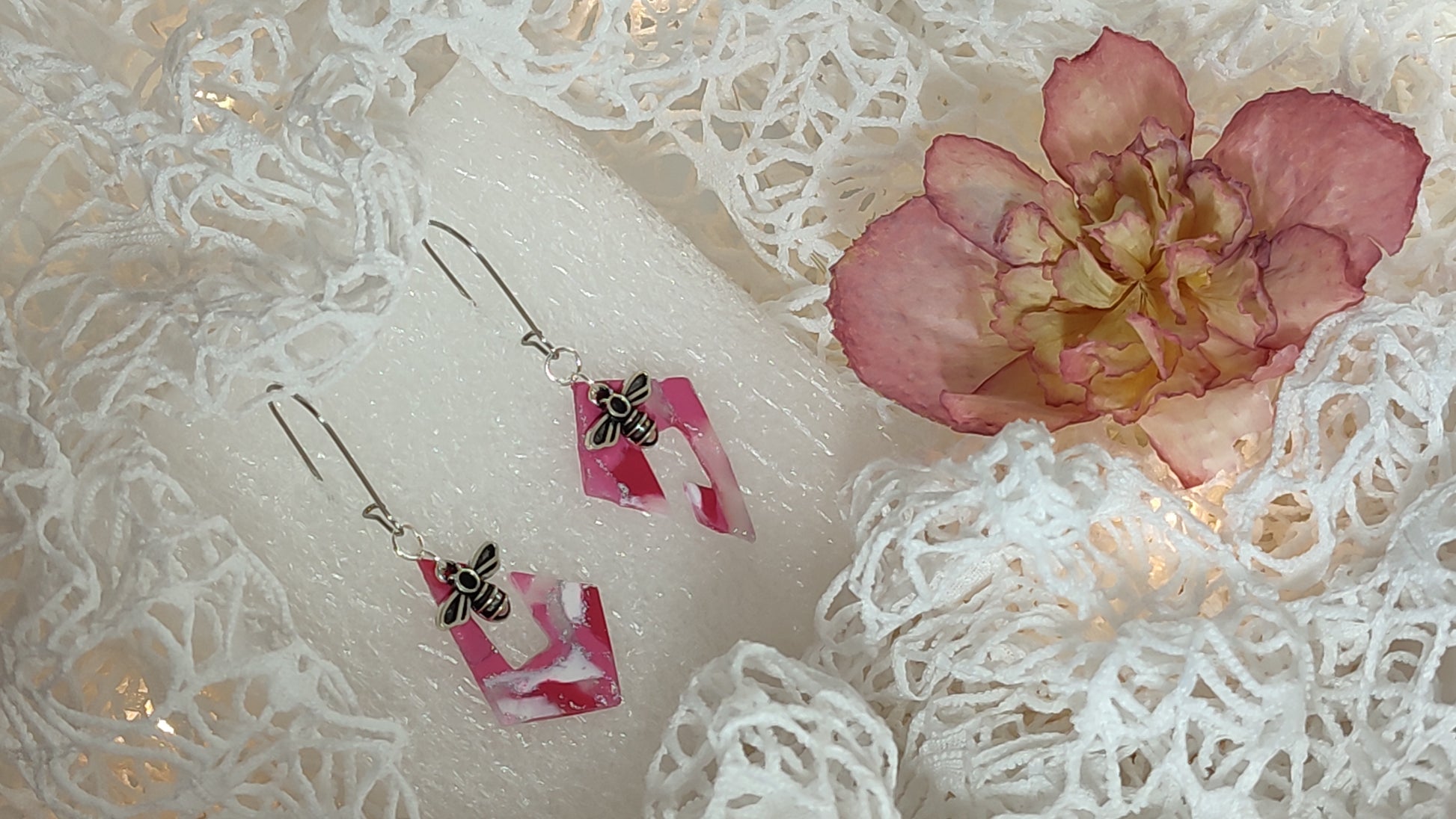 Handcrafted polymer clay earrings featuring a beautiful combination of pink, silver, and white colors. The unique design showcases a playful mix of shapes and textures, perfect for adding a touch of elegance to any outfit.