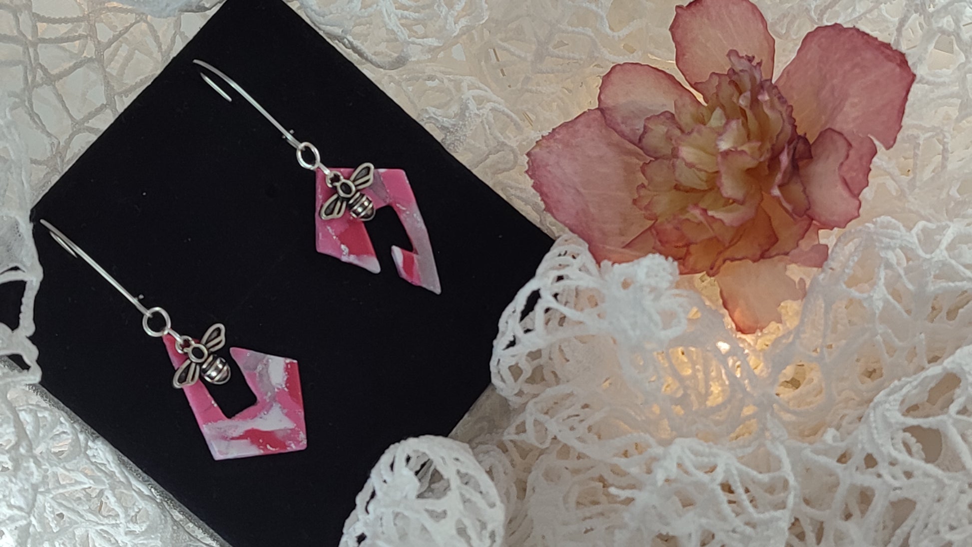 Handcrafted polymer clay earrings featuring a beautiful combination of pink, silver, and white colors. The unique design showcases a playful mix of shapes and textures, perfect for adding a touch of elegance to any outfit.